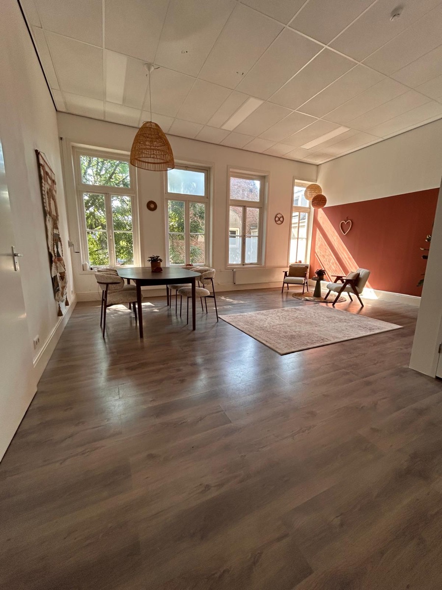 De hele praktijkruimte in Purmerend met tafel, tapijt en fauteuils