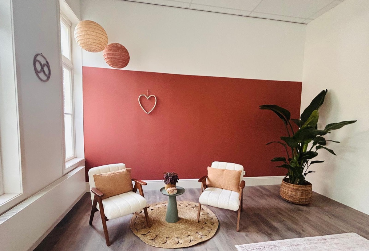 Twee fauteuils voor de terracotta wand in de praktijkruimte in Purmerend