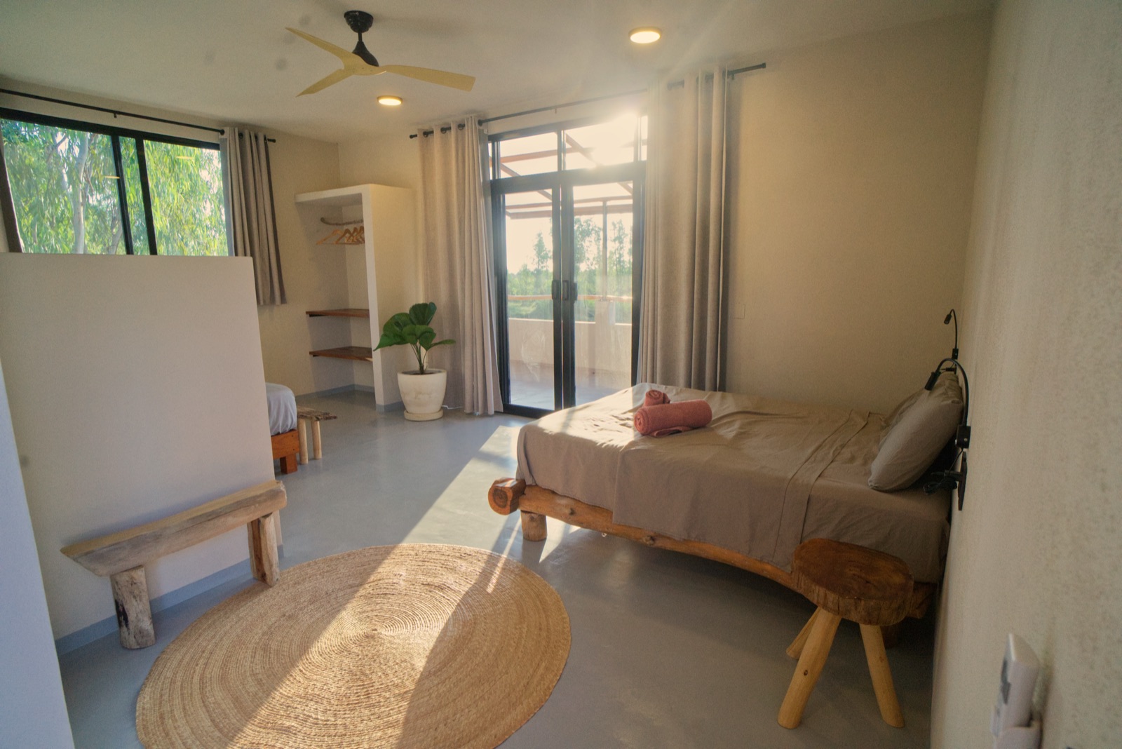 Helles Apartment mit Bett, Holzbank und Blick ins Grüne