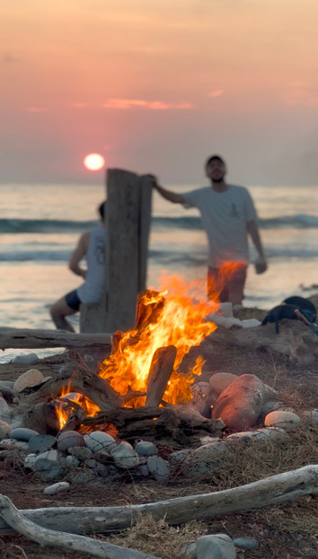 Lagerfeuer am Strand bei Sonnenuntergang